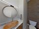 Unique bathroom features an oval mirror, modern lighting, wood sink and textured accent wall at 1509 Winslow St, Las Vegas, NV 89117