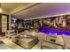 Inviting covered patio with a fire pit, offering views of the backyard pool, waterfall, and lush landscaping at 1509 Winslow St, Las Vegas, NV 89117