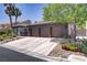 Spacious driveway leading to a three-car garage with meticulous desert landscaping and mature foliage at 1509 Winslow St, Las Vegas, NV 89117