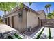 Side view of a three-car garage with a modern exterior, decorative rock features, and a privacy gate at 1509 Winslow St, Las Vegas, NV 89117