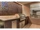 Modern outdoor kitchen with a built-in grill, stainless steel appliances, and decorative screen wall at 1509 Winslow St, Las Vegas, NV 89117