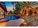Stunning backyard pool with a rock waterfall feature, complemented by lush landscaping and accent lighting, creating a resort-like atmosphere at 1509 Winslow St, Las Vegas, NV 89117