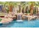 Close-up of a pool with a rock waterfall and lush tropical plants at 1509 Winslow St, Las Vegas, NV 89117
