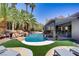 Beautiful pool with waterfall surrounded by palm trees and artificial turf at 1509 Winslow St, Las Vegas, NV 89117