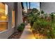 Landscaped walkway featuring lush greenery and accent lighting, offering a tranquil path alongside the home at 1509 Winslow St, Las Vegas, NV 89117