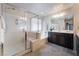 Bright bathroom featuring a glass shower, soaking tub, and double sinks, creating a luxurious space at 151 Duckhook Ave, Las Vegas, NV 89148