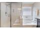 Modern bathroom with a glass-enclosed shower, soaking tub, and neutral decor, offering a spa-like feel at 151 Duckhook Ave, Las Vegas, NV 89148