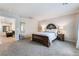 Inviting bedroom featuring neutral carpet and a comfortable bed with side tables and lamps at 151 Duckhook Ave, Las Vegas, NV 89148