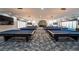 Spacious billiard room featuring multiple pool tables under modern lighting fixtures and a cozy fireplace at 151 Duckhook Ave, Las Vegas, NV 89148