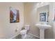 Cozy powder room with a pedestal sink, modern toilet, and stylish wall art at 151 Duckhook Ave, Las Vegas, NV 89148