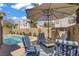 Inviting backyard pool area with comfortable seating and shaded umbrella for relaxation at 1604 Imperial Cup Dr, Las Vegas, NV 89117