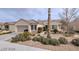 Single-story home showcasing beautiful landscaping with rock and mature desert plants at 1652 Black Fox Canyon Rd, Henderson, NV 89052