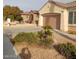 A single-story home with a two-car garage surrounded by desert landscaping at 1652 Black Fox Canyon Rd, Henderson, NV 89052
