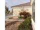 The side of a house with a garden hose, rock landscaping, and a bougainvillea at 1652 Black Fox Canyon Rd, Henderson, NV 89052