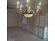Open living room with shuttered windows and elegant chandelier, perfect for relaxing or entertaining guests at 1652 Black Fox Canyon Rd, Henderson, NV 89052