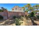 Exterior view of a residential community featuring mature landscaping, a brick wall, and stucco architecture at 1717 Dwayne Stedman Ave, Las Vegas, NV 89106