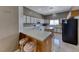 Functional kitchen with oak cabinets, white countertops, a breakfast bar, and modern black appliances at 1717 Dwayne Stedman Ave, Las Vegas, NV 89106
