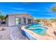 The backyard is designed for relaxation with a pool, spa, and outdoor seating area at 1727 Sonoran Bluff Ave, Henderson, NV 89014