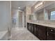 A primary bathroom featuring dual sinks, dark cabinetry and tile flooring at 1727 Sonoran Bluff Ave, Henderson, NV 89014