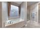 A bathtub featuring a window for natural light and a marble finish at 1727 Sonoran Bluff Ave, Henderson, NV 89014