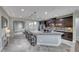 Spacious kitchen featuring a large granite island, gray tile flooring and pendant lighting at 1727 Sonoran Bluff Ave, Henderson, NV 89014