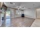 Bright living room with wood floors, fireplace, fan, and sliding glass doors to the backyard at 1727 Sonoran Bluff Ave, Henderson, NV 89014