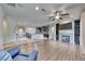 Open-concept living room and kitchen with hardwood floors, a fireplace, and ample natural light at 1727 Sonoran Bluff Ave, Henderson, NV 89014