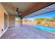 Inviting covered patio with ceiling fan offers serene views of the pool and backyard oasis at 1727 Sonoran Bluff Ave, Henderson, NV 89014