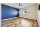 Spacious bedroom featuring hardwood floors, a ceiling fan, a large window, and an accent wall at 1792 Gentle Brook St, North Las Vegas, NV 89084