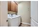 Functional laundry room with modern washer and dryer, and wooden overhead cabinets at 1792 Gentle Brook St, North Las Vegas, NV 89084