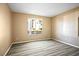 Neutral bedroom with wood-look flooring and ample light from the window at 2101 Sealion Dr # 108, Las Vegas, NV 89128