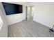 Bright bedroom with hardwood floors, neutral walls, and a mounted television with an open closet at 2105 Kendall Hill Ave, Las Vegas, NV 89106