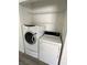 Convenient laundry room featuring a stacked washer and dryer, and built-in storage shelves above at 2105 Kendall Hill Ave, Las Vegas, NV 89106