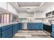 Well-lit kitchen boasts ample counter space, blue lower cabinets, and stainless steel appliances at 2230 Wagon Ave, Pahrump, NV 89048