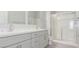 Bathroom featuring double sinks, white cabinets, a walk-in shower, and white countertops at 2305 W Horizon Ridge Pkwy # 524, Henderson, NV 89052