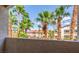 Balcony view showcasing palm trees and neighborhood buildings against a blue sky, offering a glimpse of community living at 2305 W Horizon Ridge Pkwy # 524, Henderson, NV 89052