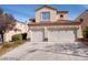 Two-story home featuring a two-car garage, tan stucco exterior, and a well-maintained driveway in a suburban neighborhood at 256 Camino Viejo St, Henderson, NV 89012