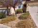 Home's front yard with minimal desert landscaping, including gravel, bushes, and a small tree at 256 Camino Viejo St, Henderson, NV 89012