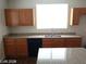 Bright kitchen featuring wood cabinets, granite countertops, stainless sink, and black dishwasher at 256 Camino Viejo St, Henderson, NV 89012