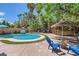 Inviting backyard oasis with a sparkling pool, lush landscaping, and a tiki bar for outdoor entertaining at 2608 Prospector Mine Ave, North Las Vegas, NV 89031