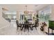 Elegant dining room featuring marble floors, modern chandelier, a view of the living room, and large windows at 2608 Prospector Mine Ave, North Las Vegas, NV 89031
