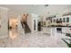 Open-concept interior featuring marble floors, a staircase, and a modern kitchen with an island at 2608 Prospector Mine Ave, North Las Vegas, NV 89031