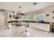 Modern kitchen featuring marble floors, white cabinets, stainless steel appliances, and a center island at 2608 Prospector Mine Ave, North Las Vegas, NV 89031