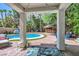 Backyard pool with patio, tropical landscaping, a built-in bar, and comfortable lounge chairs at 2608 Prospector Mine Ave, North Las Vegas, NV 89031