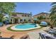 Backyard pool featuring lounge chairs, a spa, a lush backyard and a view of the home's rear elevation at 2608 Prospector Mine Ave, North Las Vegas, NV 89031