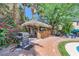 Backyard tiki bar with comfortable seating, grill, and lush tropical landscaping at 2608 Prospector Mine Ave, North Las Vegas, NV 89031