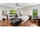 Spacious bedroom with hardwood floors, modern fan, large windows and comfortable seating at 2610 Eldora Estates Ct, Las Vegas, NV 89117