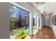 Bright hallway featuring hardwood floors, modern lighting, and an open view to the landscaped courtyard at 2610 Eldora Estates Ct, Las Vegas, NV 89117