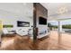 Bright living room featuring a modern fireplace, hardwood floors, and an open patio with views at 2610 Eldora Estates Ct, Las Vegas, NV 89117