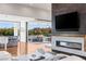 Contemporary living space with a modern fireplace, large TV, and a view of the outdoor living area at 2610 Eldora Estates Ct, Las Vegas, NV 89117